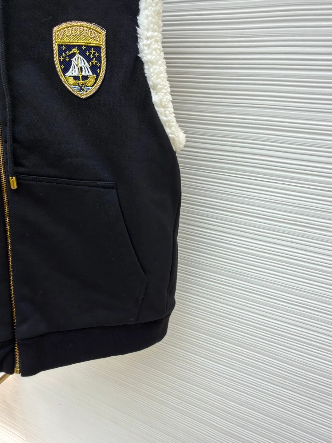 LOUIS VUITTON embroidered reversible hooded vest ●Original version: purchased and developed by 14599 ●Item number: 1681399-C00 ●Fabric: lamb wool fabric ●Technology: embroidery production ●Color: black/white ●Version: fitted version ●Weight: about 1040 grams ●Size: S-M-L-XL ●Description: This vest adopts a double-sided design. One side is made of high-quality knitted fabric, which is crisp, stylish, skin-friendly and comfortable; the other side is made of imitation lamb wool, which is fluffy, soft and has good warmth retention. The hooded part is made of knitted fabric of the same color and is equipped with a two-way zipper with a metal zipper puller, which is smooth and durable. The flip design of cotton knitted surface and comfortable suede surface is very ingenious. It uses advanced double-sided weaving and composite technology to perfectly integrate the two materials and make the transition natural when switching; the shield logo patch uses high-precision patching technology, with neat edges and clear and three-dimensional patterns; the embroidered logo on the back uses fine embroidery technology, with fine and even stitches, and the logo is perfectly integrated into the back design; the drawstring hood uses high-quality drawstrings and precision sewing technology, which not only ensures the adjustment function of the hood, but also enhances the overall sense of leisure. The overall wiring is straight and delicate, the fabric is comfortable and soft, and the color is consistent without color difference. It can be matched with the same style to create a fashionable look and control various occasions. Customized accessories, complete with three standards, same style for men and women!